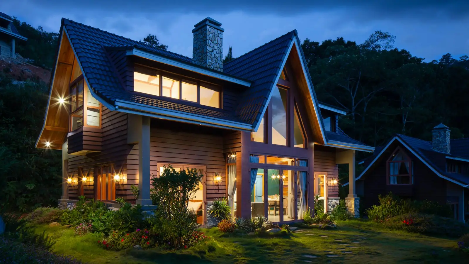 Suburban home with a paved driveway and front garden at dusk