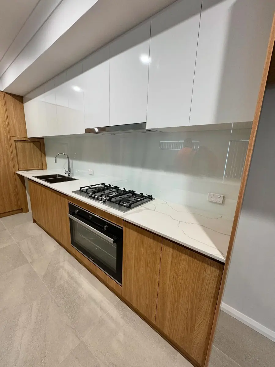 Kitchen with a white glass splashback installed by Hightym